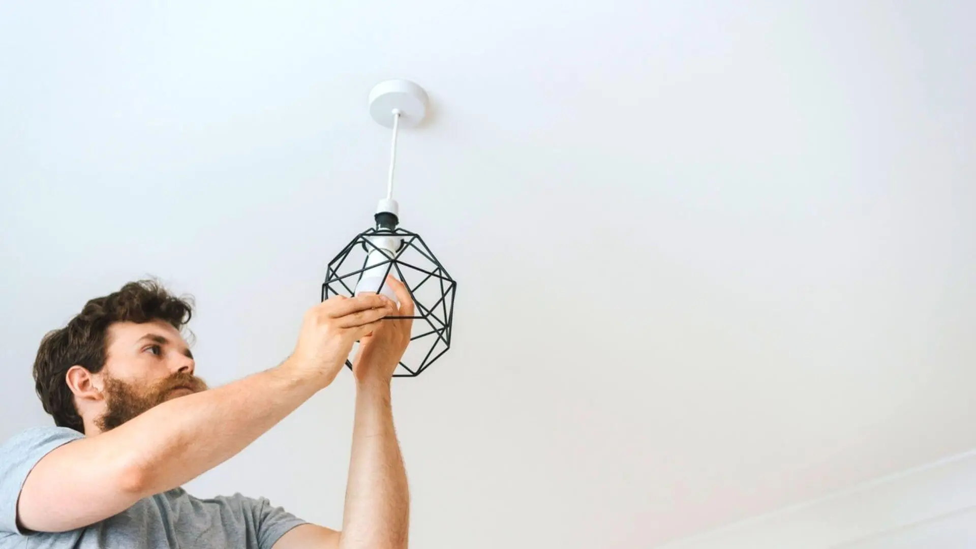 Man Changing Light Bulb Hanging Fixture