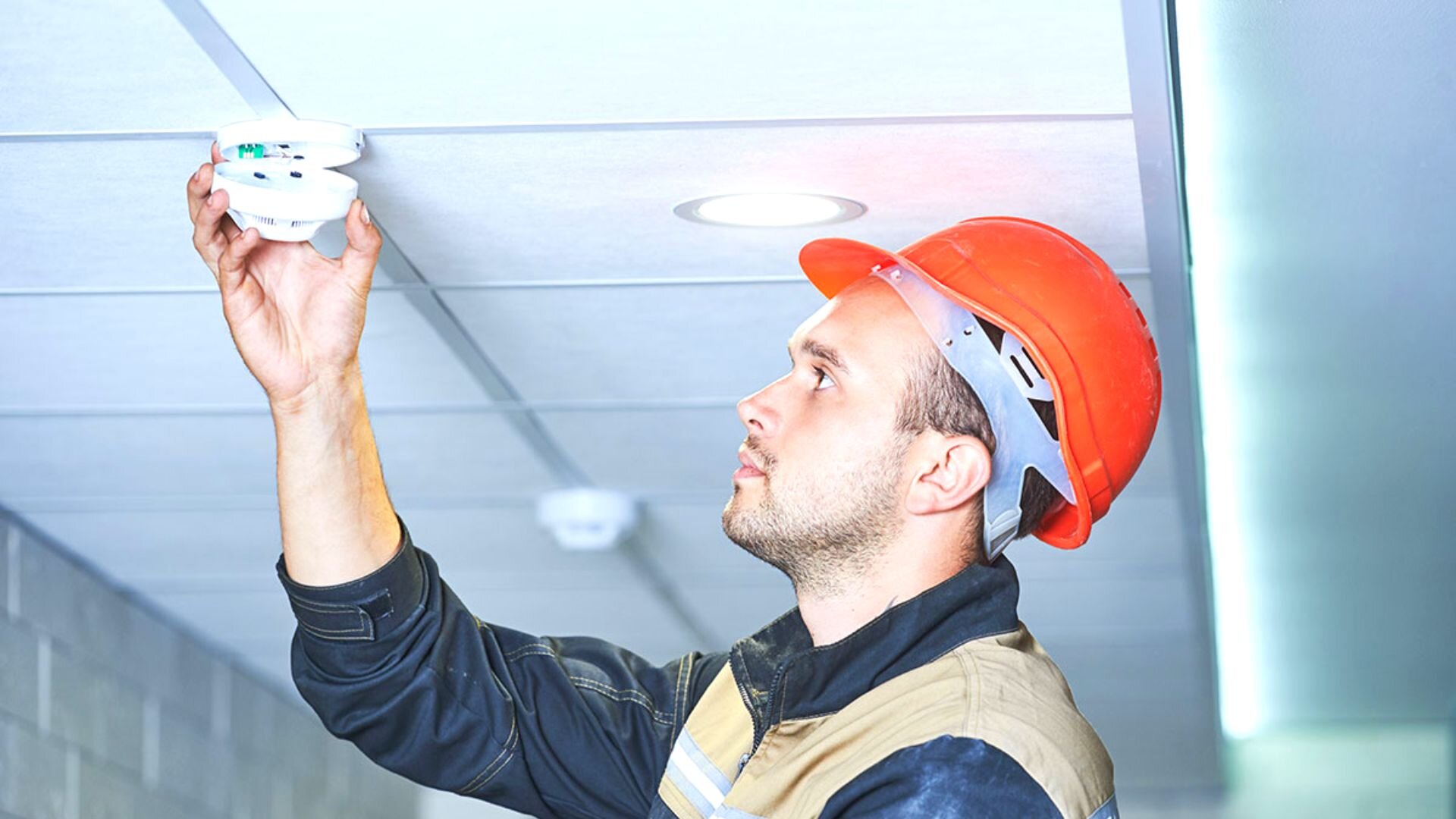 Operson Removing Smoke Detector Ceiling