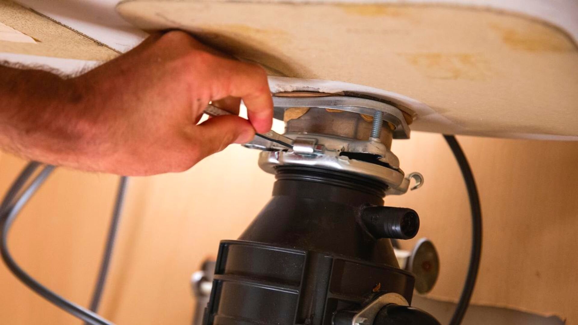 Fix Your Leaking Garbage Disposal With Our Guide Fixed Today Plumbing   Person Fixing Leaking Garbage Disposal 