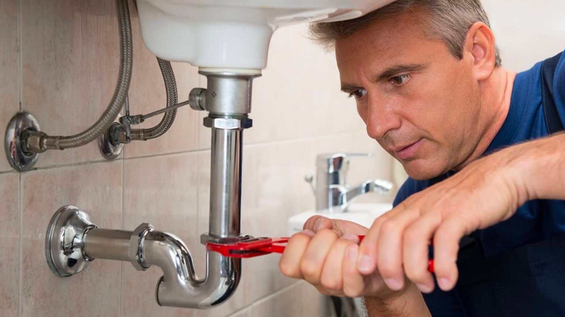 Guy Fixes Sink Red Spanner