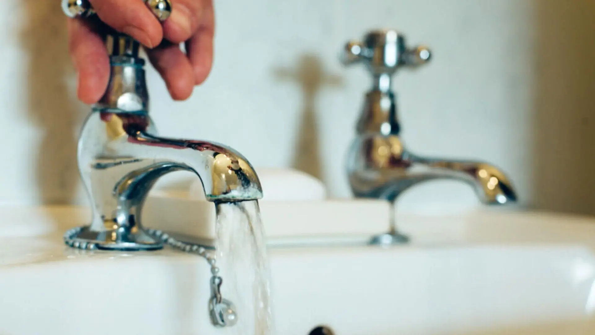 Person Turning On Leaking Faucet Person Turning Leaking Faucet